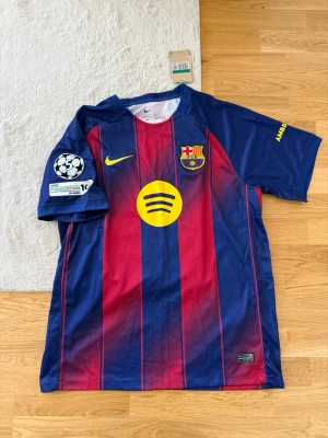 FC Barcelona matchtröja Lamine Yamal - Säljer en FC Barcelona matchtröja från Nike med Lamine Yamal och nummer 10 på ryggen. Tröjan är blå och röd med gula detaljer, klubbmärke, sponsorloggor och Champions League-märke på ärmen. Tillverkad i lätt och ventilerande material.