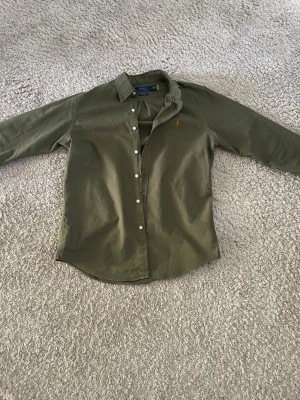  skjorta från Polo Ralph Lauren - Stilren olivgrön skjorta från Polo Ralph Lauren. Avänd endast 1 gång, säljer eftersom den är lite stor. Nypris 1800kr mitt pris 699.