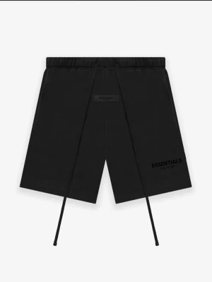 Svarta shorts från Essentials - Svarta shorts från Essentials med långa snören i midjan och tryckt logga på ena benet. De har en avslappnad passform och elastisk midja, perfekta för en chill och stilren look.
