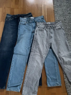 Tre par Jack and Jones jeans - Tre par jeans i raka modeller, ett par mörkblå, ett par ljusblå och ett par grå. Klassisk femficksdesign och normal midja. Perfekta för en avslappnad och trendig look. För alla 649kr, 300kr st