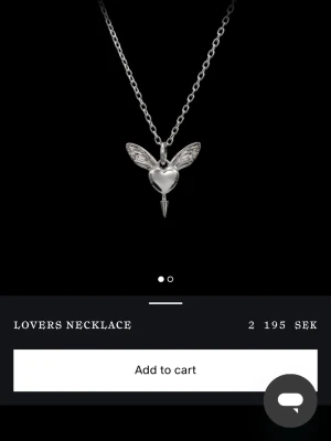 Lovers Necklace i silver - Snyggt halsband i silverfärg med ett hängsmycke format som ett hjärta med vingar och en pil. Kedjan är tunn och elegant, perfekt för att ge en unik touch till din stil. Märket är inte synligt på bilden. Nypris 2 195kr, jag säljer för 1800kr