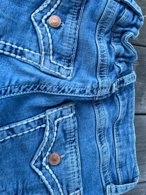 Blå bootcut jeans från Gina Tricot  - Snygga blå bootcut jeans från Cubus med klassisk femficksdesign och dekorativa sömmar. Jeansen har justerbara spännen i midjan och är tillverkade i mjuk denim med lätt tvättad look. Perfekta för en avslappnad och trendig stil original pris 450 säljer för 150.