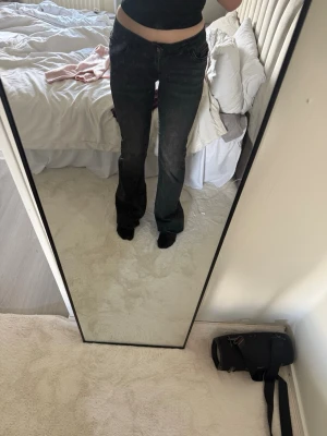 Nelly svarta bootcut jeans med fickor - Säljer ett par svarta bootcut jeans med klassisk femficksdesign och snygga sömmar på bakfickorna. Jeansen har låg midja och utsvängda ben, perfekta till sneakers eller boots. Materialet är denim med lite stretch för skön passform. Men dom är lite slitna nertill❤️
