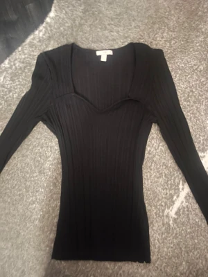Svart ribbad topp från H&M - Snygg svart ribbad topp från H&M.❤️ använd två gånger och inga tecken på användning!🥰🥰