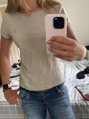 Beige basic t-shirt - En enkel och stilren beige t-shirt med rund hals och korta ärmar. Tillverkad i mjuk bomull som känns skön mot huden. Perfekt att matcha med jeans eller shorts för en avslappnad look.