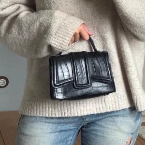 Svart handväska i croco-skinnlook - Snygg svart handväska med croco-mönster och stilren form. Väskan har både handtag och en lång kedja för axeln. Skicka prisförslag!!!💗💗