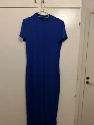 Blå långklänning från SHEIN - En enkel och stilren blå långklänning från SHEIN i storlek M. Klänningen har korta ärmar, rund halsringning och rak passform. Perfekt för dig som gillar minimalistisk stil och vill ha något bekvämt och snyggt. Använd 1 gång. 
