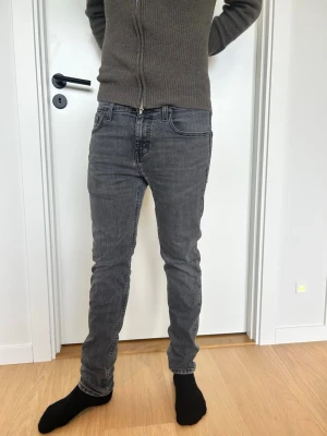 Levi's 511 grå jeans slim fit - Säljer ett par grå Levi's 511 jeans med slim passform. Jeansen har klassisk femficksdesign, svarta sömmar och Levi's ikoniska läderpatch bak i midjan. Materialet är mjukt jeans i bomull med lite stretch för extra komfort. Perfekta för dig som gillar en smalare siluett.