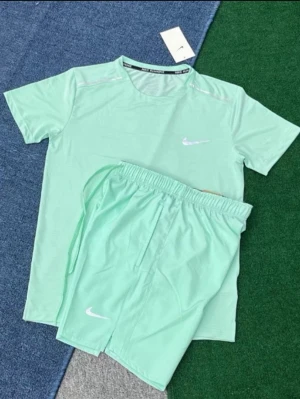 Nike miller set Mintgrönt - Snyggt mintgrönt träningsset från Nike med t-shirt och shorts. Båda plaggen har Nike-logga i vitt och är tillverkade i ett lätt och snabbtorkande material, perfekt för träning eller sportaktiviteter. T-shirten har rund hals och shortsen har resår i midjan.