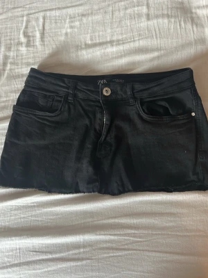 Svart jeanskjol från Zara - Säljer en jättesnygg jeanskjol ifrån Zara. Kjolen är svart, kort och lågmidjad. Storlek M men skulle säga att den passar allt ifrån XS-M eftersom materialet är stretchigt. Säljer för 400kr, kom gärna med bud eller frågor om ni har några!💞