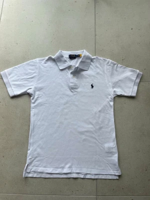 Vit pikétröja Polo Ralph Lauren - Säljer denna snygga vita piké tröjan som är i bra skick och är i storlek S men passar M också. Så skulle säga att den passar stor S och liten M             Hör av dig vid några funderingar.        MVH larre 