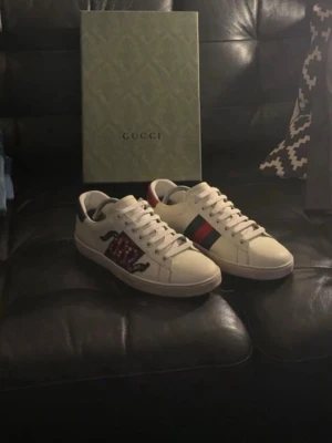 Gucci Ace  - Gucci Ace sneakers i vitt läder med klassiska Grönan och röda ränder på sidan samt en broderad orm i rött och svart. skorna är i jätte fint skick och såklart äkta! ‼️Byten kan vara intressanta kom med förslag‼️om ni har några funderingar är det bara att fråga på 😁