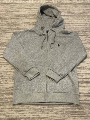 Grå Polo Ralph Lauren zip hoodie  - Säljer en grå ralph lauren zip hoodie i storlek S. Priset är inte fast så skicka prisförslag 😁