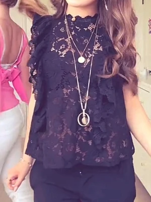 Svart spetsblus med volangdetaljer - Säljer en svart blus i spets med volangdetaljer längs axlarna och ärmarna. Blusen är ärmlös och har ett blommigt spetsmönster som ger en elegant look. Perfekt att styla med smycken för en trendig outfit. Skriv för mer info och bilder💕💕