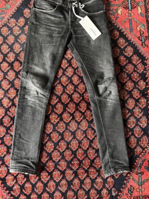 Svarta skinny jeans från Dondup - Snygga svarta jeans i slim fit-modell från Do. Jeansen har klassisk femficksdesign, smal passform och är tillverkade i ett stretchigt jeanstyg som sitter tajt längs benen. Perfekta för dig som gillar en stilren och modern look.