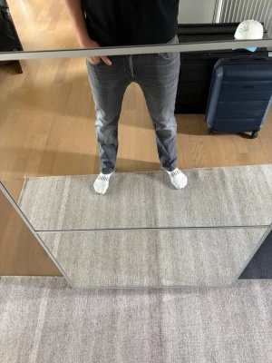 Grå raka jeans från Jack Jones  - Säljer ett par grå jeans med rak passform och klassisk femficksdesign. Jeansen har normal midja och är tillverkade i ett mjukt denimtyg. Perfekta för en avslappnad och stilren look.