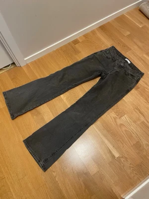 Svarta bootcut jeans - Säljer ett par svarta bootcut jeans med klassisk femficksdesign och normal midja. Jeansen har raka ben som blir något vidare nedtill och är tillverkade i ett mjukt denimtyg. Perfekta för en avslappnad och trendig look.
