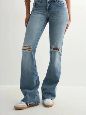 Ljusblå bootcut jeans med slitningar från Nelly! - Säljer ett par ljusblå bootcut jeans med slitna och broderade bakfickor från Nelly. Säljs pågrund utav att dom blivit för små! Superfint skick! 