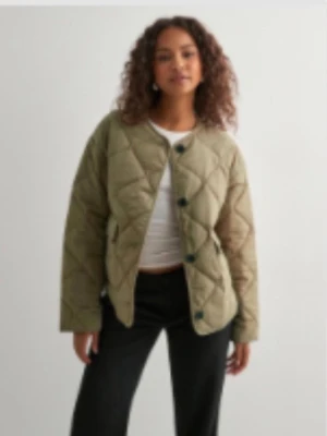 Quiltad grön jacka med knappar - Snygg quiltad jacka i olivgrönt med stora svarta knappar framtill. Den är aldrig andvänd och har prislappen på!