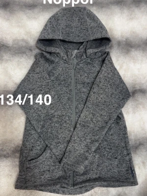 Grå hoodie med dragkedja - Mysig grå hoodie från Polarn O. Pyret med dragkedja framtill och två fickor. Tröjan har huva. passar perfekt för en avslappnad look.🌸 Noppor finns som kom direkt. Storlek 134/140