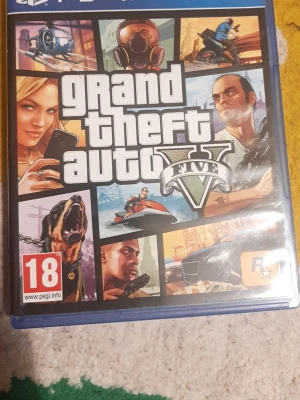 Grand Theft Auto V till PS4 - GTA V till PlayStation 4 med ikoniskt omslag. Spelet bjuder på action, äventyr och frihet i en öppen värld. Omslaget har färgstarka bilder, logotyp och PEGI 18-märkning. Perfekt för dig som gillar fartfyllda spel och spännande uppdrag.