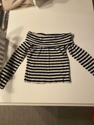 Randig offshoulder topp Brave Soul - Säljer en svartvit randig offshoulder topp från Brave Soul. Toppen har långa ärmar och är ribbad i materialet. 