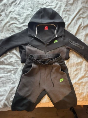 Hel nike tech tracksuit - Ett svart/mörkgrått Nike tech set. Nyskick och är knappast använt. Inga fel eller skador. Har ändast använts ett få antal gånger. Skriv gärna om ni är intresserade. Är köpt på JD-Sports (Ny pris 3000kr)