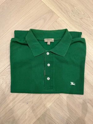 Burberry Piké  - Grön piké från Burberry  Storlek M Knappt använd Väldigt bra skick, utan anmärkningar  Rök- och djurfritt hem  Ställ gärna frågor vid minsta fundering😄