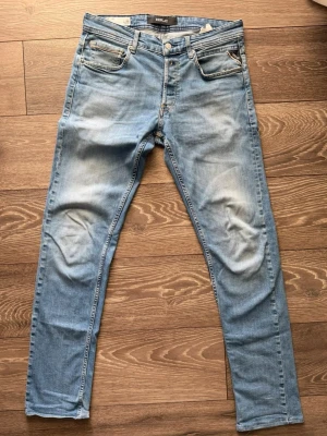  Replay grover - Snygga ljusblå Replay Grover. Jeansen har slitningar och tvättade detaljer för en avslappnad look. Tillverkade i mjukt denimtyg med skinnpatch bak i midjan.