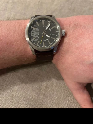 Diesel DZ1802 46mm Herrklocka - Säljer en tung kvalitetsherrklocka från Diesel i mycket gott skick. Repor på glaset som inte stör enligt bilder. Fungerar bra med nytt batteri, case i rostfritt stål, originalarmband i äkta läder, vattentät 5 bar, osv.  Nypris: 1800 SEK Begagnat pris: 1000 SEK Mitt pris: 589 SEK  Skickas alltid snabbt och spårbart (ofta samma dag) eller hämtas i Glumslöv.  Hör av dig vid frågor och se gärna mina andra annonser också!   Wear the ultimate expression of Diesel style and design evolution on your wri