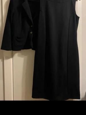 Klänning och kavaj! Ny! - Set med klänning och kavaj från!   Perfekt till fest/middag!  Totala längden på klänningen är 97 cm.  Kavaj med knappar fram, små passande axelvaddar! Stilig och elegant.  Fodralklänning med dragkedja bak.  Stretchiga material  Endast använd 1 gång är i absolut nyskick   