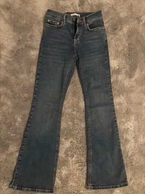 Bootcut jeans  - Säljer ett par klassiska blå bootcut jeans från. Aldrig använda. Jeansen är midwaist, snygga kontrastsömmar och en bekväm passform. Materialet är slitstark denim och färgen är mörkblå med lätt tvättade detaljer. Perfekt för dig som gillar en tidlös look.