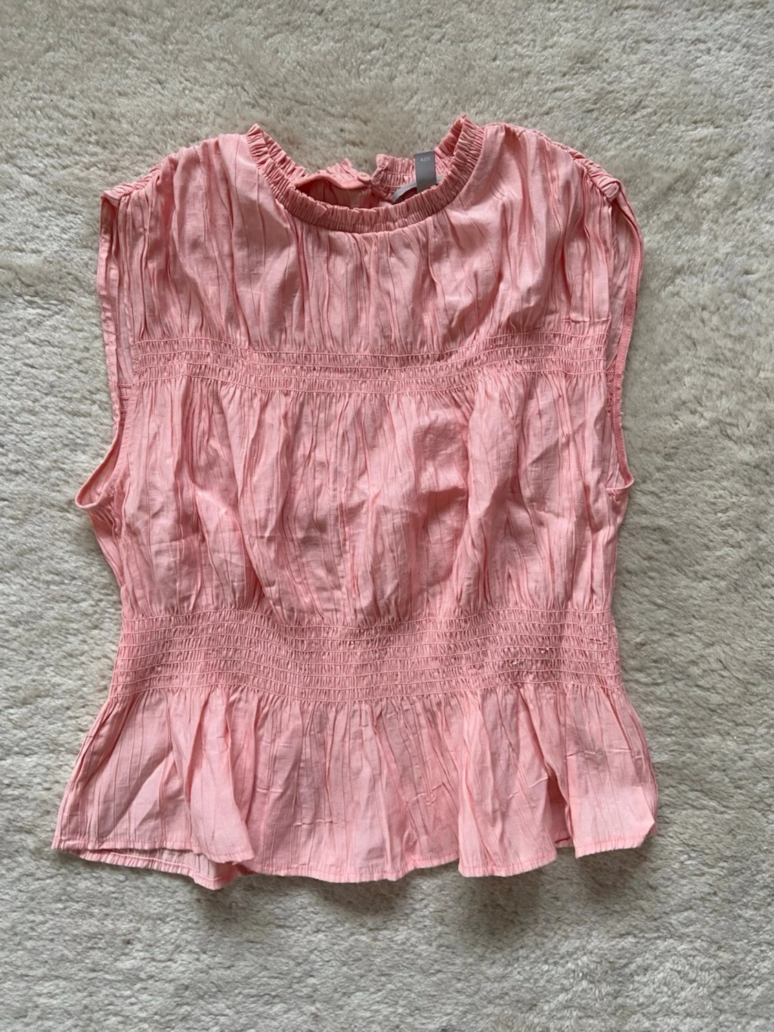 Ljusrosa smockad topp med volang