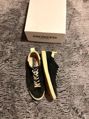 Marin blåa sneakers från Golden Goose - Snygga marin blåa sneakers från Golden Goose med vita detaljer och beige sula. Skorna har klassisk låg profil, vita skosnören och är tillverkade i mockaliknande material. Perfekta för en avslappnad och trendig stil.