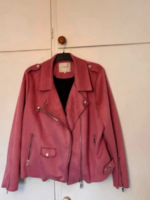 Rosa skinnjacka  - Säljer en snygg rosa bikerjacka från ONLY i mjuk mocka-look. Jackan har flera silver detaljer, passform som M/L men orginalstorlek 52