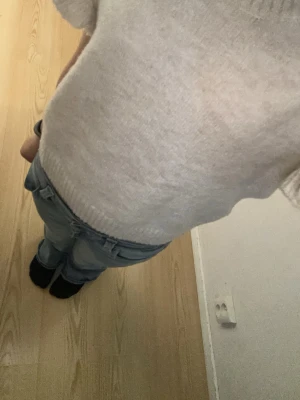 Beige stickad topp med volangärm - Söt beige stickad topp med korta volangärmar och ribbade detaljer vid hals, ärmslut och nederkant. Perfekt för dig som gillar en enkel men ändå trendig look. Materialet känns mjukt och bekvämt mot huden. Storlek syns inte men sitter perfekt på mig som e 155cm lång!