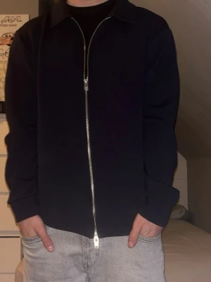 Mörkblå ziptröja från Selected Homme - Tjena! Säljer nu en väldigt fräsch och Snygg mörkblå ziptröja från Selected Homme. Den är väldigt sparsamt använd och det är nyskick. Overshirten ger en väldigt stilig touch på outfiten, och passar med väldigt många outfits och stilar. Speciellt nu när våren och sommaren är runt hörnet. Overshirten är i storlek M. Vid frågor är det bara att höra av sig. 