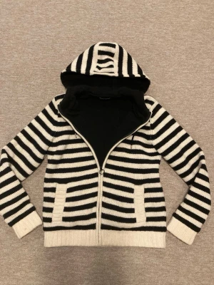 Cardigan/ Kofta från Samsoe Samsoe i Ull - Cardigan/ Kofta från Samsoe Samsoe i shetlandwool och fleece innerfoder. Tröjan är i mycket bra skick förutom någon släpp i sömmen på två ställen i fleecefodret på insidan(se bild) syns inte alls från utsidan! Tröjan är i storlek L och personen på bilden är 181 cm men koftan skulle nog passa någon lite större bättre! Hör av er vid fund