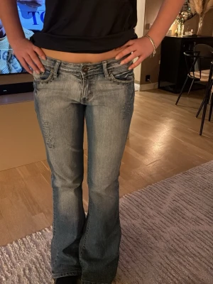 Bootcut jeans från Onako Jeans - Jättesnygga vintage jeans som är köpta här på Plick med fina detaljer. De är sparsamt använda med lite slitningar längst ner (se bild). De passar bra i längen på mig som är 168. Storleken är S/M. Passar mig bra som brukar ha S men kan även töjas ut mera.