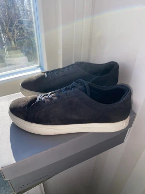 Marinblå sneakers i mocka - Stilrena marinblå sneakers i mocka med vita sulor och klassisk låg profil. Skorna har marinblå skosnören och en enkel, minimalistisk design som passar till det mesta. Perfekta för dig som gillar en clean look. Skorna kommer stora i storlek de är storlek 38 och passar även 39 och 39,5