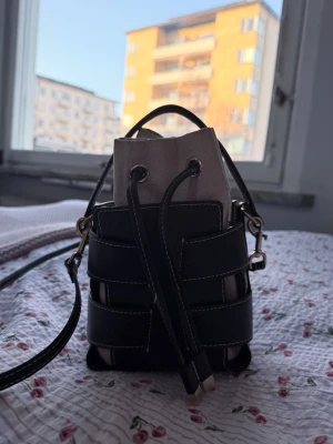 Svart och beige bucket bag - Trendig liten handväska i bucket-modell med svart läderlook och beige tyginsats från H&M ❣️❣️