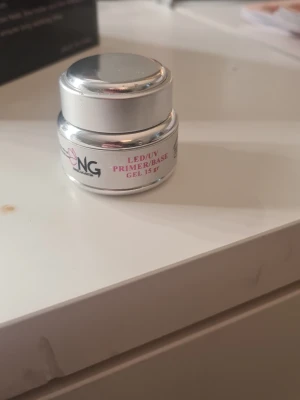 NG LED/UV Primer/Base Gel 15 gr - LED/UV Primer/Base Gel i en silverfärgad burk på 15 gram. Gelen är genomskinlig och används som bas eller primer vid nagelförlängning och nagelbyggnad. Perfekt för dig som vill ha en hållbar grund till dina naglar.