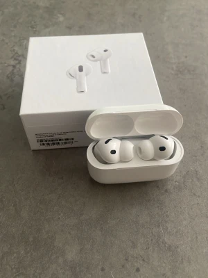 Apple AirPods Pro 3 trådlösa hörlurar - Snygga vita AirPods Pro 3 från Apple med stilren design och laddningsetui. Hörlurarna är in-ear och har silikontoppar för bekväm passform. Perfekta för musik, samtal och träning. Levereras i originalförpackning.
