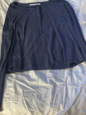 Mörkblå långärmad topp med knyt - Mörkblå långärmad topp från lager 157 med knyt framtill vid halsen. Tunn och mjuk i materialet, perfekt för lager-på-lager. Enkel och stilren design med rund halsringning. Aldrig använd.