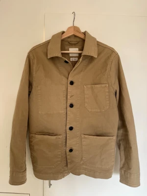 Beige overshirt Selected Homme - Silren overshirt/skjortjacka från Selected Homme. Riktigt schysst plagg som passar i princip till allt. Passar någon kring 175 cm och 60-70 kg. Perfekt inför våren med en skjorta under! Hör av er vid frågor