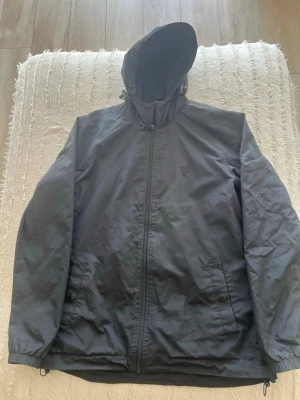 Lyle & Scott Vindjacka - Vindjacka perfekt bär vår och höst. Extremt skön passform. Köpt för 3 månader sedan. Säljer pga för stor storlek.