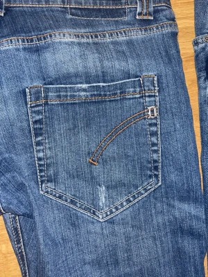 Dondup jeans navy. - Snygga blå jeans från Dondup med klassisk fyrficksmodell och kontrastsömmar. Jeansen har en diskret tvättad look och detaljer som tryckt text på linningen. Perfekta för dig som gillar stilrena och trendiga denimplagg. Riktigt feta dondups pris: 699. Fraktas inom en dag. DET STÅR STORLEK 34 MEN PASSAR 32.