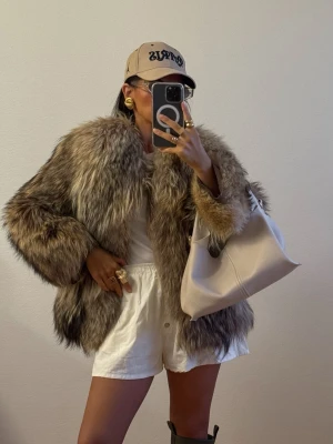 Äkta Pälsjacka Päls Jacka Bomber Bomberjacka Raccoon Räv - Säljer en riktigt fluffig och långhårig pälsjacka i olika nyanser av brun och grå. Jackan är kraglös. Längd 60cm. Fr armhåla till armhåla 47cm. Har ej ngn knäppning. Fint vintage skick 