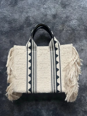 Bohemisk sommar väska - Säljer en jättegullig väska med bohemisk vibe, den passar perfekt inför sommaren och våren när man t.ex. går till stranden. Den är helt slutsåld och köptes 2023
