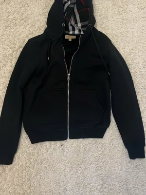 Svart zip hoodie  - Snygg svart burberry kofta. Koftan är i bra skick, den har varit använd men inga skador alls. Säljs pågrund av att den inte kommer till användning längre, pris kan diskuteras.